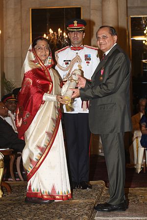 Photograph of Ramdas Pai receiving an award from then–President of India Padma Bhushan, a guard standing in the middle behind them both