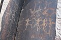 Petroglyphs of ancient tribal dance and animals