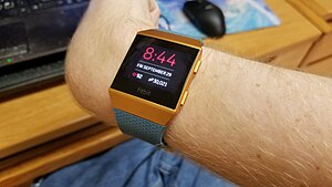 A smart watch displaying heart rate on a person's wrist