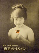 Affiche publicitaire montrant le haut d'une femme dénudée et souriante, tenant dans la main un verre de vin et le portant à ses lèvres.