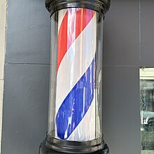 Poste rojo, blanco y azul que suele encontrarse en el exterior de las barberías