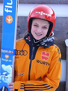 Une jeune femme avec un casque qui sourit.