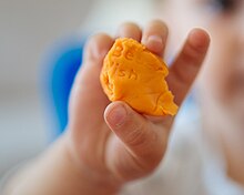 Little girl holding plasticine. (49810941302).jpg