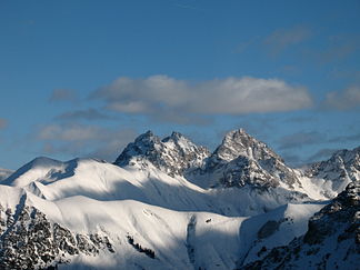 Krottenspitze, Öfnerspitze und Großer Krottenkopf; deutlich kontrastieren die weichen schneebedeckten aus Allgäuschichten bestehenden Almen gegen den schroffen Hauptdolomit, aus denen die genannten Gipfel sowie die Partien rechts unten und links unten bestehen.