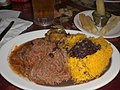 Ropa vieja, zwarte bonen, rijst, en gefrituurde cassave met bier (Cuba).