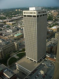 Aerial view of the WoodmenLife Tower (center). Image features a white 30-story skyscraper with its associated parking garage.