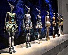 Several mannequins in a row, each wearing a different dress and shoes