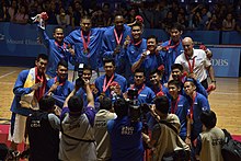 Team photo, with each blue-uniformed member wearing a gold medal