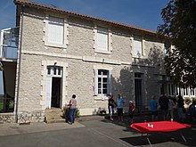 cour de l'école avec au rez-de-chaussée une ancienne salle de classe transformée en salle polyvalente