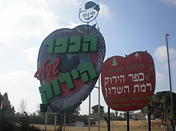 שלטים בכניסה לכפר הירוק