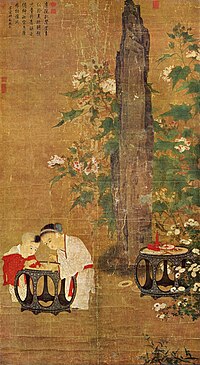 A portrait oriented painting depicting two young children, a boy and a slightly older girl, playing with figurines on a table in a garden. Behind them is a tall rock flanked by branches of a flowering tree.