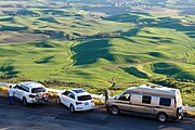 Tourists and photographers park alongside the access road