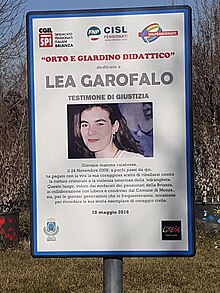 Photographie couleur d'un panneau avec un portrait de Lea Garofalo, un texte explicatif et des logos