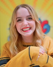 McKenna Grace smiling while wearing a yellow shirt at the 2023 German Comic Con, in Dortmund