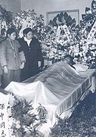 Zhou's wife and daughter stand next to his body during his funeral (1964)