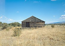 A wooden structure in the middle of a field