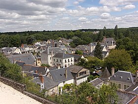 Photographie en couleurs de maisons dans une vallée au milieu d'arbres.