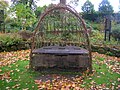 A living willow seat on the lawn outside the house.