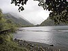 A bay surrounded by green tree covered mountains