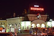 Gare de nuit avec des bus garés en premier plan sur le parking