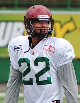 A football player in a white jersey and a red helmet.