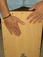 Cajón player demonstrating typical hand positions on a flamenco cajón.