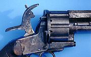 A close-up of the hammer on a LeMat Pinfire Revolver, showing the pivoting striker that could be used to fire either the pinfire cartridges in the revolving chambers or the secondary smoothbore barrel.[3]