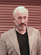 Simon Callow dans le rôle d'Armand Duquesne III