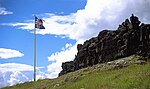 Rock formation and a flag of Iceland on a pole