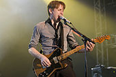 Colour photograph of Franz Ferdinand lead singer Alex Kapranos performing live in 2008.