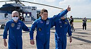 Robert Behnken gives a thumbs up to onlookers as he boards a plane at Naval Air Station Pensacola