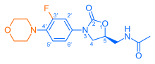 Skeletal formula of N-{[(5S)-3-[3-fluoro-4-(morpholin-4-yl)phenyl]-2-oxo-1,3-oxazolidin-5-yl]methyl}acetamide, highlighting the morpholino and fluoro groups in orange, with the rest in blue. The carbon atoms of the parent chain are numbered.