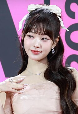 Wonyoung at the Melon Music Awards in 2023. She is wearing a light pink dress and has a bow in her hair.