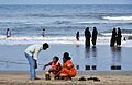 Un foyer préparant quelques rituels avant l'immersion des Ganesh, sur une plage du Tamil Nadu.