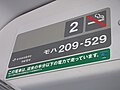 車内のステッカー。下の緑のラベルに「この電車は、従来の半分以下の電力で走っています」との表記がある （2011年1月3日 武蔵野線）