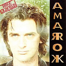 The Amarok album cover. It shows a photograph of Oldfield's face along with a red stamp containing his name at the top left. On the right side arranged vertically is the name Amarok in gold coloured capital letters; the letters A, M and O appear normally, but R and K are mirrored about the vertical stroke of the letter.