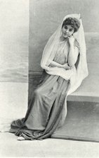 Young white woman in ancient Greek costume, sitting on a bench