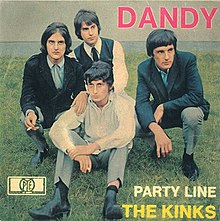 The Kinks sit together straight-faced on a patch of grass