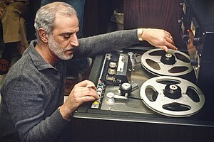 A middle-aged man operating a tape machine