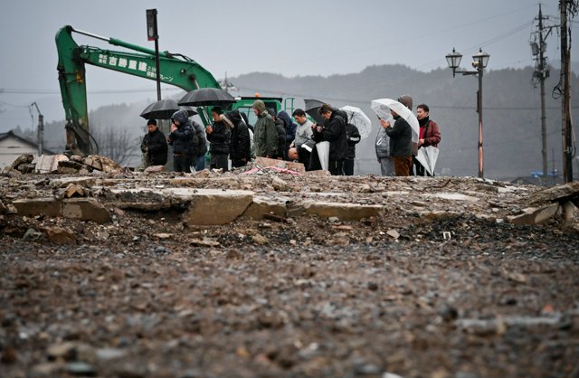 輪島朝市周辺の大規模火災現場を訪れ、犠牲者を追悼する人たち=2025年1月1日午後4時19分、石川県輪島市河井町、伊藤進之介撮影