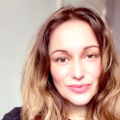 A fair-skinned woman with long hair smiling.