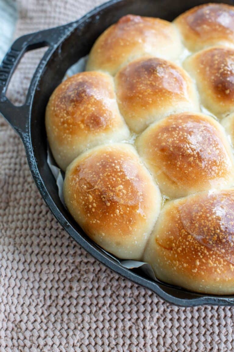 Soft Potato sourdough dinner rolls baked with melted butter on top in a skillet pan.