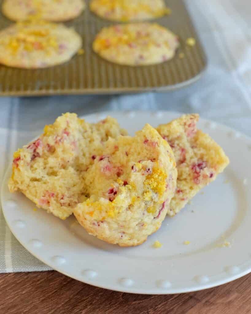 Cranberry orange muffins broken open on a plate.