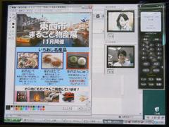 Windows用のIP電話ソフトとUSB接続のIPフォン、ビデオカメラを用い、さらにデータ共有が可能なホワイトボードソフトを使ってちらし作成を協業するデモの1場面