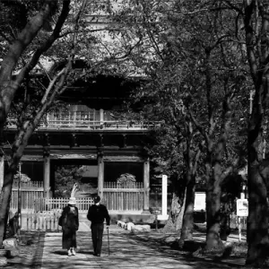 Two figures walking in front of Nio-Mon Gate