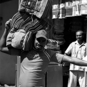 Man carrying textile on shoulder