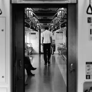 Man walking with head hanging low in train