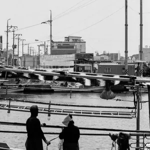 Man and woman fixing up fishnet in Sokcho harbor