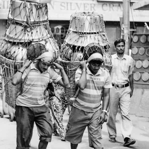 Men carrying metal container with Namlo and Doko