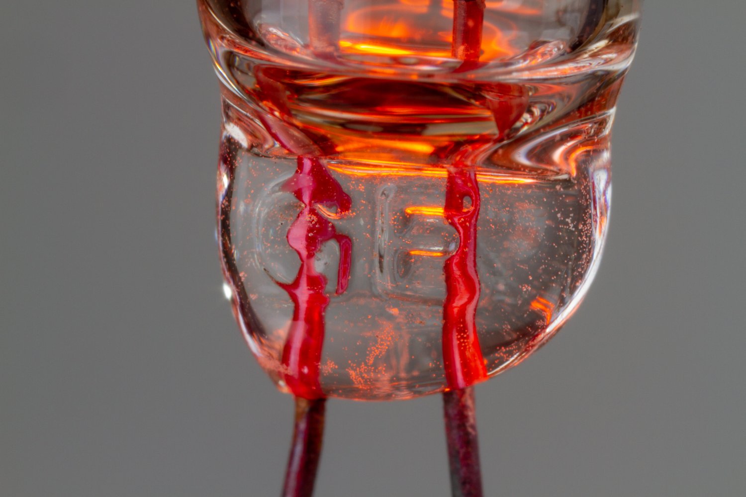 Closeup of a small neon bulb showing GE stamped in the base and wires going through the glass